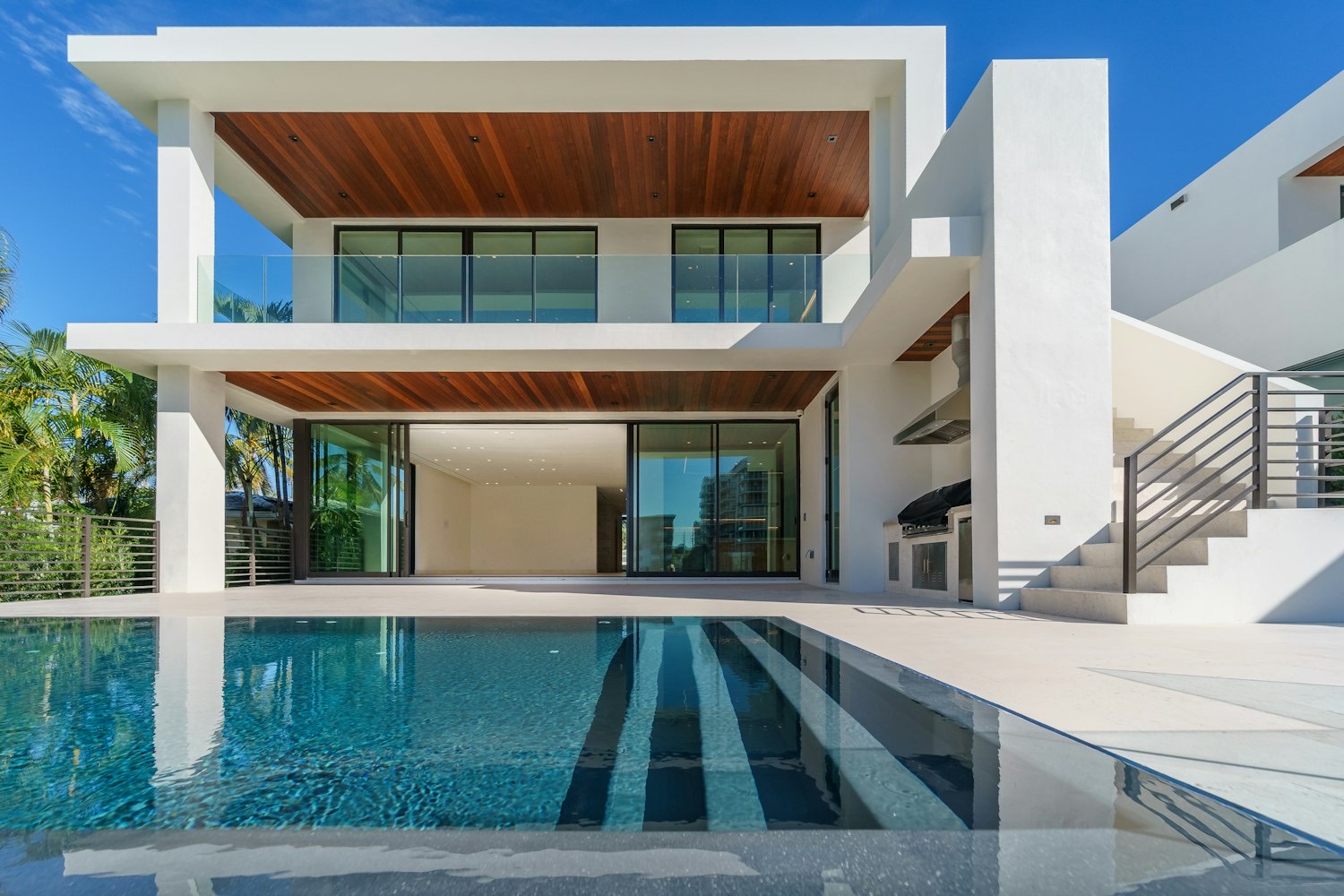 Modern white villa with timber soffits and a reflecting pool